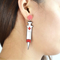 Boucles d'oreilles en forme de Seringues portés par une femme - Bijoux fantaisie pour infirmières et aide-soignantes